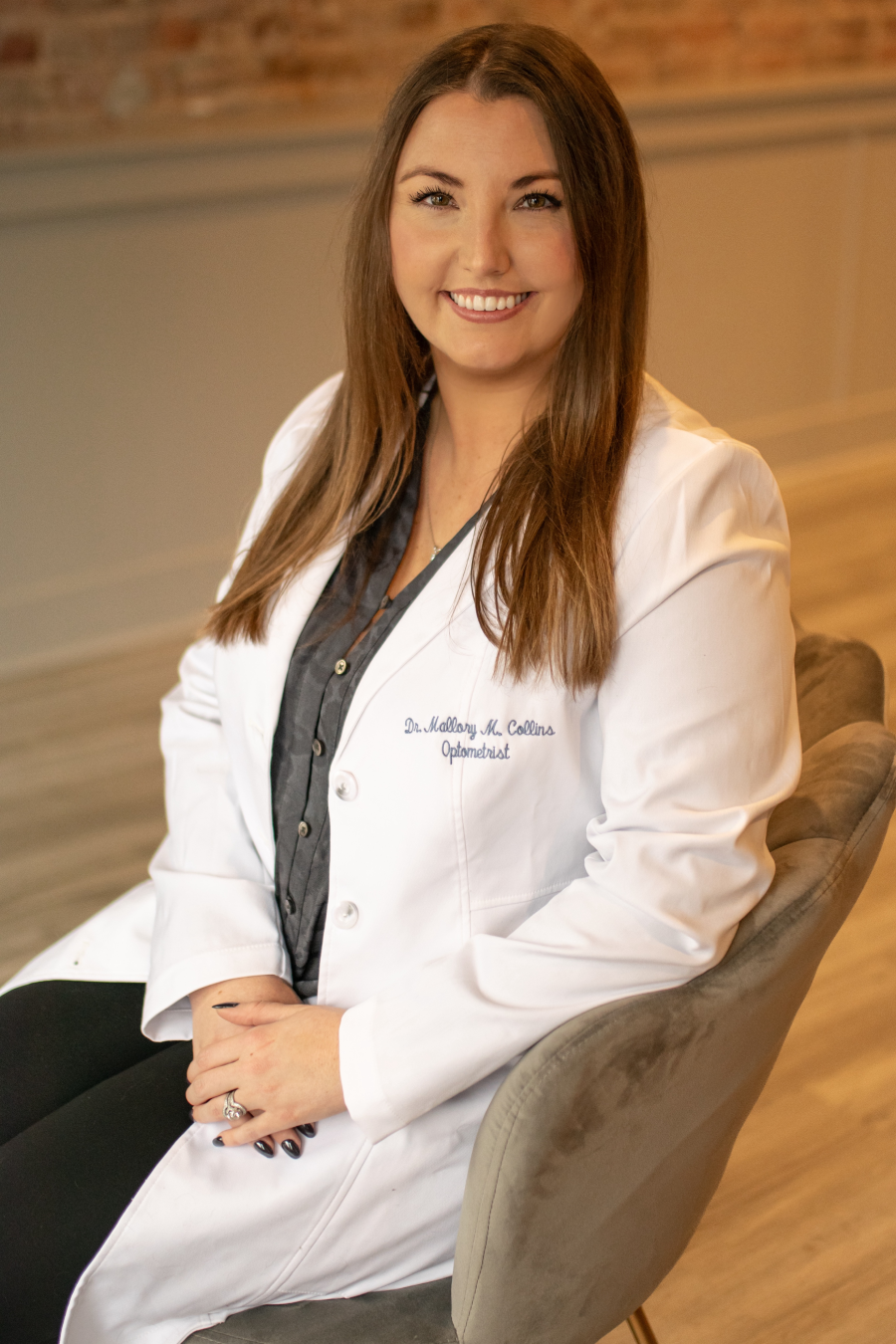 Smiling portrait of Dr. Mallory Collins, optometrist at Hometown Eyecare, seated in modern office - Hometown Eyecare